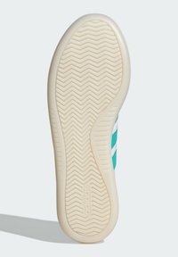 Shoe outsole with a textured cream color, featuring a herringbone pattern, three teal stripes, and 'adidas' logo embossed.