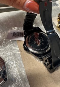 Zwarte roestvrijstalen polshorloge met een gepolijste afwerking, waterbestendig tot 3 ATM, en een gedetailleerde gegraveerde achterzijde van de kast.