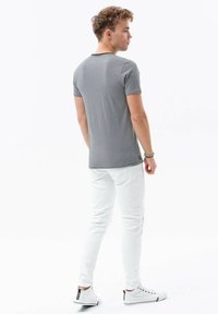Grå kortærmet t-shirt, slim fit, i bomuldsblanding. Båret med hvide slidte skinny jeans og hvide canvas sko.