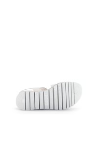 White sandal with a textured outsole, featuring a striped pattern, thick sole, and open design. Showcases durability and comfort.