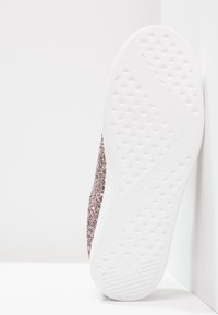 Sneaker rosa scintillante con tomaia texturizzata e suola in gomma bianca con motivo a diamante per la presa. Ideale per uso casual.