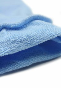 Blauwe stof met een gestructureerd, geweven oppervlak. De stof is zacht en heeft een subtiele glans met een licht opgerolde rand.