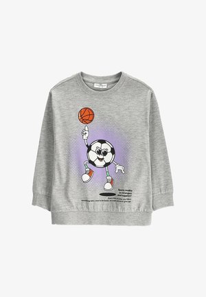 Szara dziecięca bluza z postacią piłki nożnej w stylu kreskówki, która kręci piłkę do koszykówki na palcu oraz z motywującym tekstem sportowym.