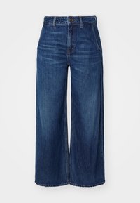Weite Jeans aus dunkelblauem Denim. Mit hoher Taille, Fronttaschen und subtilen Ausbleichungen. Saum sauber ohne Einschüsse.