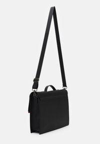 Sort messenger-taske med et strømlinet design, lavet af glat materiale. Har en justerbar rem, et håndtag på toppen og minimale hardware-detaljer.