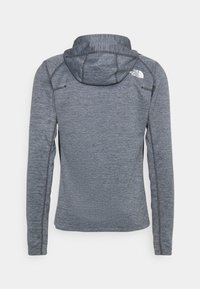 Grå huva jacka med en strukturerad tyg, som har långa ärmar och en logotyp på övre ryggen. Designen inkluderar kontrasterande sömmar.