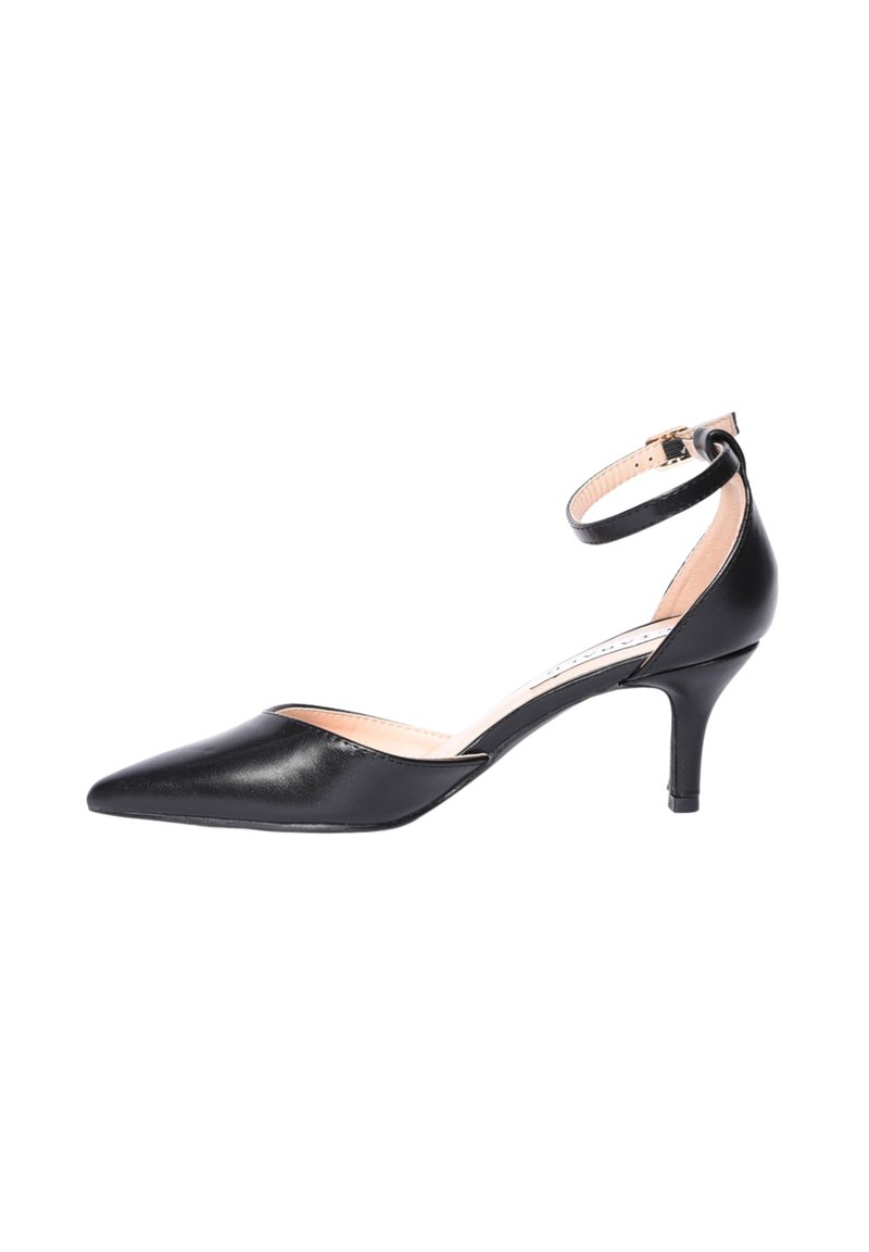 Scarpa nera in pelle con punta a punta, tacco kitten, cinturino alla caviglia e fibbia dorata su sfondo bianco.