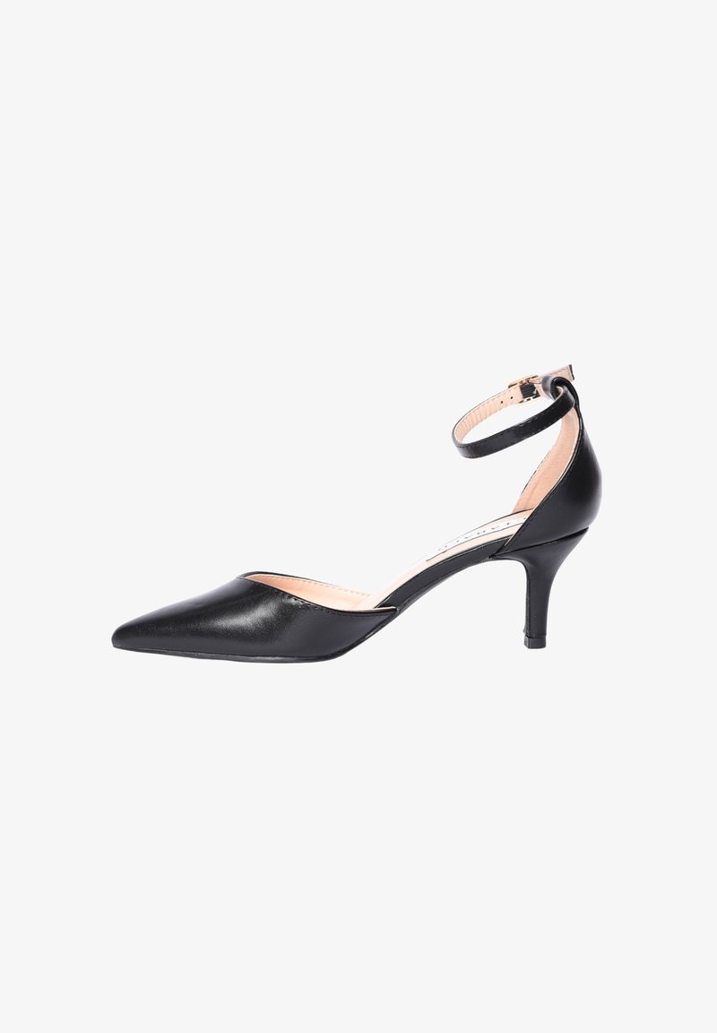 Scarpa nera in pelle con punta a punta, tacco kitten, cinturino alla caviglia e fibbia dorata su sfondo bianco.