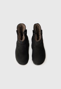 Schwarze Knöchelstiefel mit glattem Äußeren und softem, strukturiertem Innenfutter. Verfügt über einen seitlichen Reißverschluss und eine Zuglasche für bequemes An- und Ausziehen.