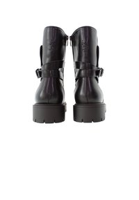 Botas de tobillo de cuero negro con un acabado suave, suela gruesa, cremalleras laterales y correas ajustables en la parte superior. Detalle de logotipo grabado.