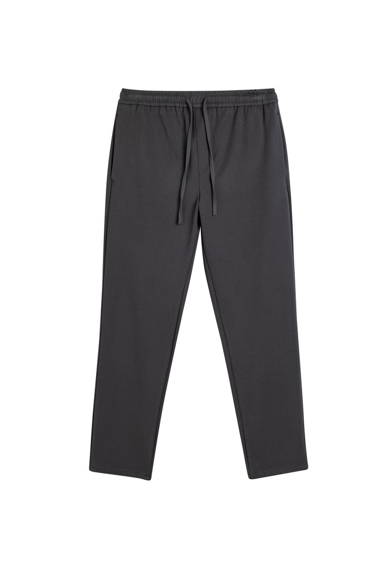 Grå joggebukser lavet af blødt stof med elastisk talje og snøre, elastiske manchetter og sidelommer, der har en glat overflade og en tætsiddende design.