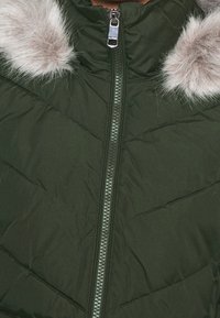 Zielona pikowana kurtka typu puffer z wysokim kołnierzem i odpinanym szarym futrzanym obszyciem, wyposażona w srebrny zamek błyskawiczny oraz detale w postaci przeszyć w kształcie jodełki.