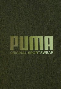 Tessuto verde oliva con logo metallico dorato "PUMA" e testo "ORIGINAL SPORTSWEAR" stampato sotto.