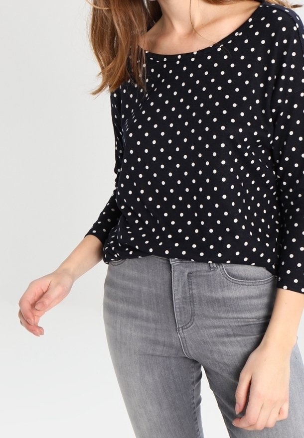 Tummansininen pilkkupaita, joka on valmistettu kevyestä kankaasta, jossa on leveä pääntie ja kolmannes-osa hihat, yhdistettynä harmaisiin slim fit -farkkuihin.
