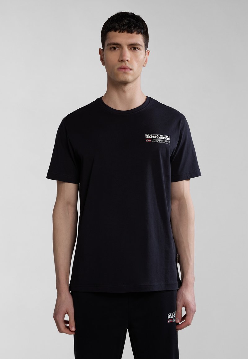 Schwarzes Baumwoll-T-Shirt mit rundem Hals, kurzen Ärmeln und einem Logo-Print auf der Vorderseite. Einfaches Design, lässige Passform, kombiniert mit schwarzen Hosen.