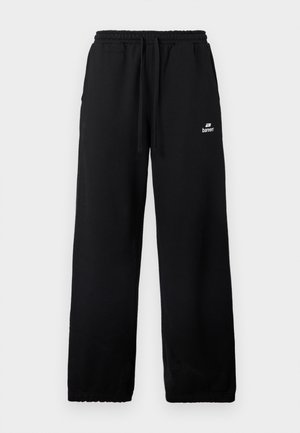 Mustat leveälahkeiset collegehousut, joissa on joustava vyötärönauha, kiristysnyöri, sivutaskut ja pieni valkoinen Bareen-logo oikeassa reidessä.