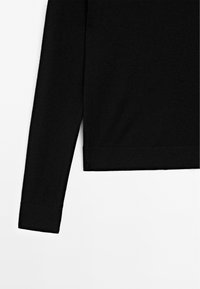 Maglia nera a maniche lunghe con taglio dritto, realizzata in un tessuto morbido. Presenta un orlo e dei polsini a costine, evidenziando un design minimalista.
