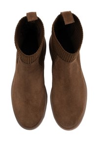 Hnědé semišové kotníkové boty s vroubkovaným textilním límcem, poutkem na patě a vzorovanou gumovou podrážkou. Hladký povrch bez viditelných vzorů nebo akcentů.