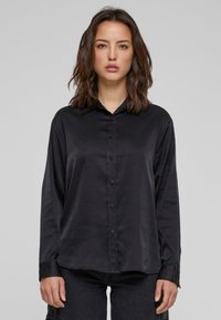 Zwarte long sleeve shirt van een gladde, glanzende stof met een knoopsluiting aan de voorkant, een verspreide kraag en accentueringen op de manchetten. Minimalistisch ontwerp.