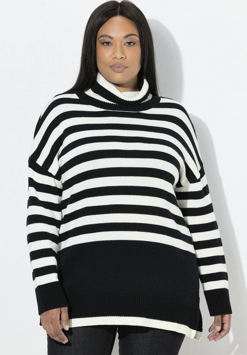 Maglione a collo alto a righe bianco e nero con una vestibilità ampia, polsini e orlo a costine, caratterizzato da un collo alto e fessure laterali per una maggiore libertà di movimento.