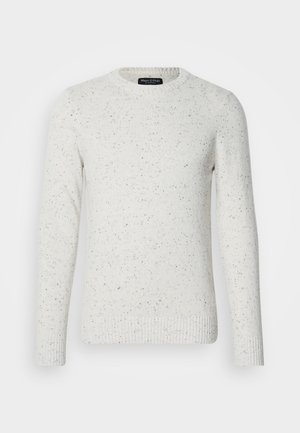 Valge tekstuuriga sviiter, millel on täpiline muster, ümar kaelus ja soonikmode varrukad. Valmistatud kudumismaterjalist, millel on pikad varrukad.