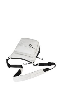 Witte crossbodytas met een gladde stoftextuur, verstelbare zwarte schouderband, dubbele ritszakken en een minimalistisch ontwerp.