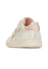 Sneaker beige per bambini con tacco glitter rosa, lati perforati, due cinturini in velcro e rivestimento interno rosa imbottito.