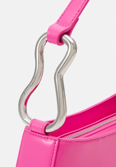 Borsa a tracolla in pelle rosa con manico metallico curvo e dettagli con zip, con una texture liscia e una forma strutturata.