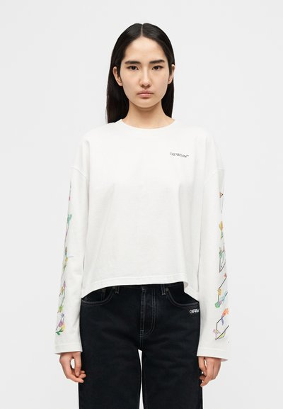 Λευκό πουκάμισο με μακριά μανίκια και cropped σχεδιασμό, με πολύχρωμα λουλουδένια σχέδια στα μανίκια και το λογότυπο "Off-White™" στο στήθος. Μαύρο τζιν.