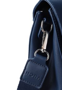 Námořnická kožená kabelka s hladkou texturou, kovovými detaily a odnímatelným popruhem. Obsahuje logo značky na kožené visačce.