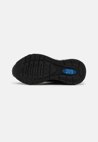 Sole di scarpa atletica nera con motivi testurizzati, caratterizzata da un logo blu prominente e materiale in gomma resistente per una maggiore trazione.