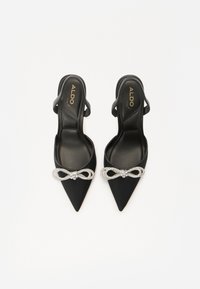 Escarpins slingback en satin noir avec bouts pointus, ornés d'un nœud embellie de strass à l'avant. Marque ALDO à l'intérieur.
