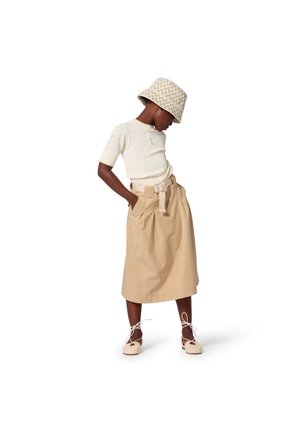 Lichtbeige katoenen rok met een tailleband, gecombineerd met een aansluitend wit gebreid topje met een textuurpatroon en een licht patroonem hoedje.