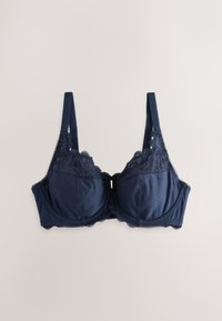 Soutien-gorge bleu marine avec bordure en dentelle, bonnets rembourrés, bretelles réglables et motif discret à pois, posé à plat sur un fond clair.