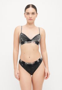 Svart bralette och matchande bikiniunderbyxor med denimstruktur, med kontrastsömmar och en etikett vid midjan.