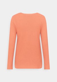 Haut à manches longues de couleur corail orangé, en tissu côtelé texturé, avec un col arrondi. Il présente une coupe droite et est sans ornements.