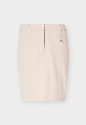 Béžová sukňa do polovice kolien s pútkami na opasok, predným gombíkom a zipsom, a malým okrúhlym strieborným príveskom na pravej strane.