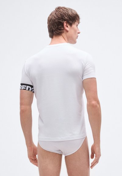 Hvid tætsiddende t-shirt med korte ærmer, rund hals og et sort bånd med teksten "RED2" på højre ærme.