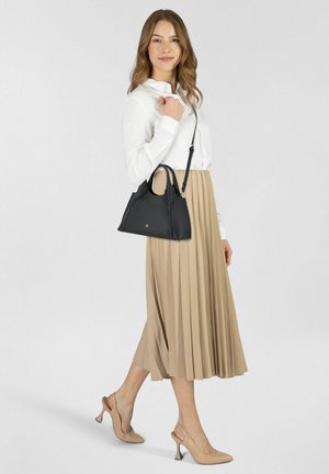 Schwarze Lederhandtasche mit strukturiertem Design, doppelten Griffen und verstellbarem Schultergurt. Faltenrock in Beige und Nude-Pumps vervollständigen das Outfit.