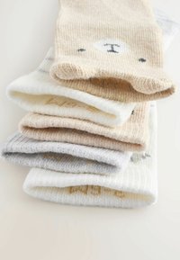 Set aus fünf Paar Socken aus weichen, strukturierten Stoffen. Die Farben umfassen Beige, Grau, Weiß und helles Tan. Einige haben Bärenmuster und Akzente.