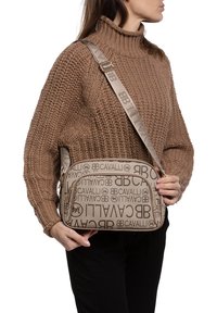 Bruine canvas schoudertas met logo-opdruk, een rechthoekige vorm, gladde textuur en een enkele verstelbare schouderband. Voorzien van een gouden rits.