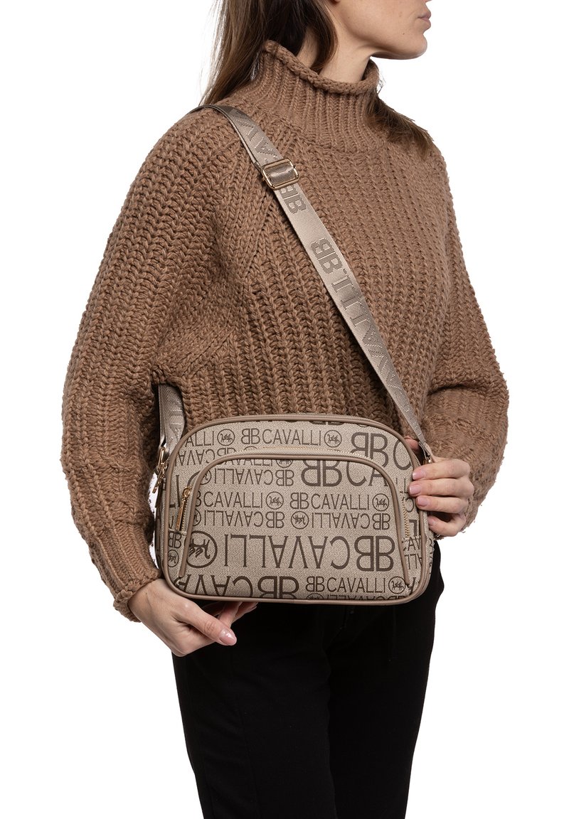 Bruine canvas schoudertas met logo-opdruk, een rechthoekige vorm, gladde textuur en een enkele verstelbare schouderband. Voorzien van een gouden rits.