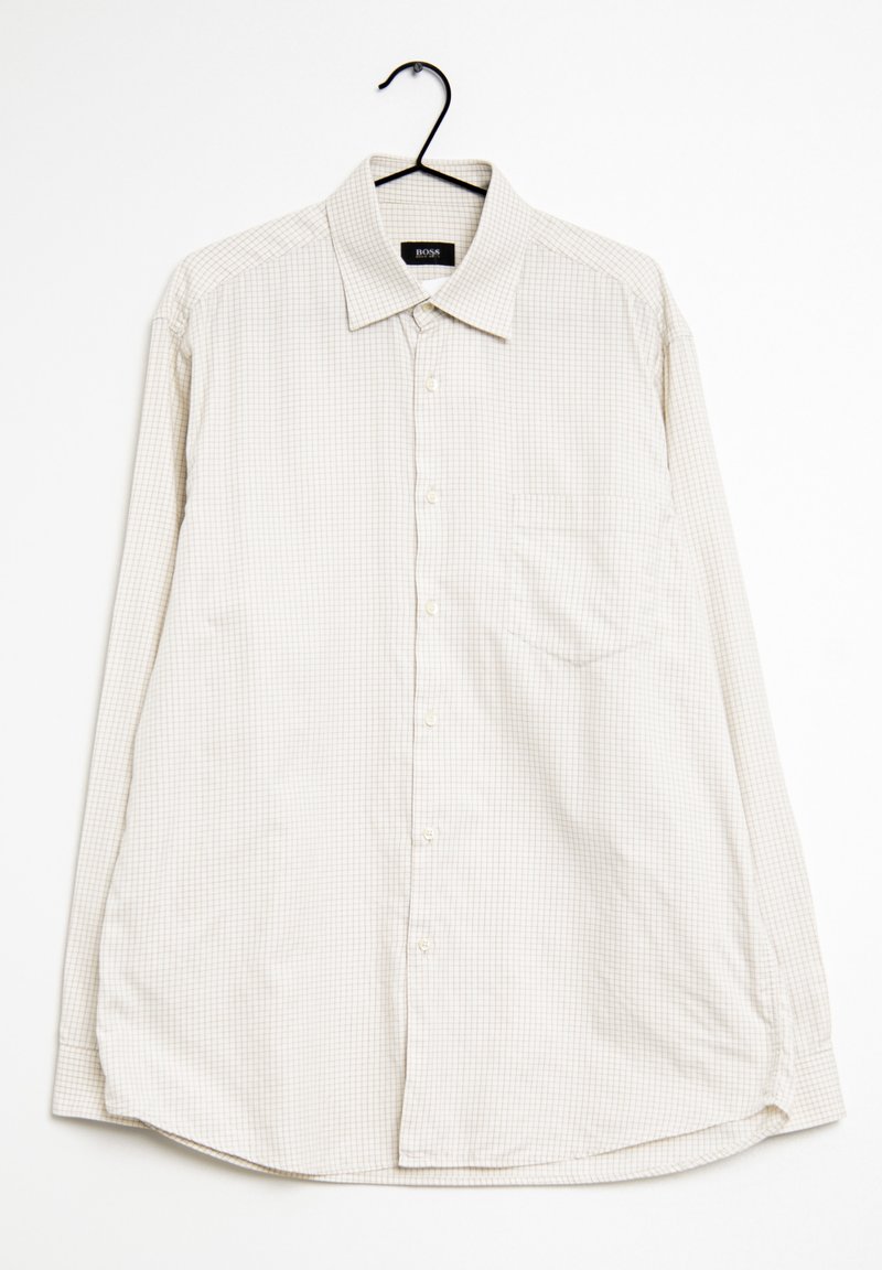 Ljust beige långärmad skjorta med rutigt mönster, knappstängning, krage och en enda bröstficka. Hänger på en svart krok.