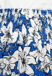 Tecido floral azul e branco com contornos pretos, apresentando uma faixa de cintura elástica com franzido e um acabamento texturizado.
