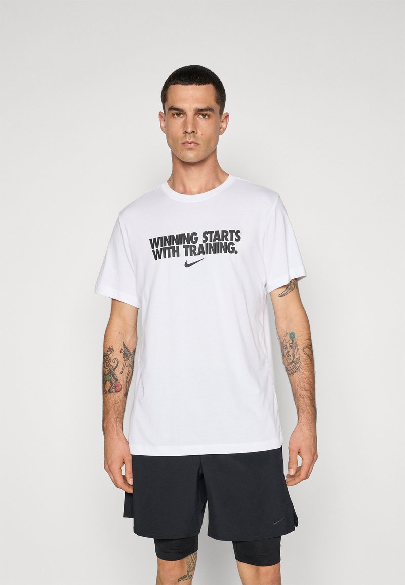Hvit bomull t-skjorte med svart trykt tekst "SEIER STARTER MED TRENING" og Nike-logo, rund hals, korte ermer, avslappet passform.