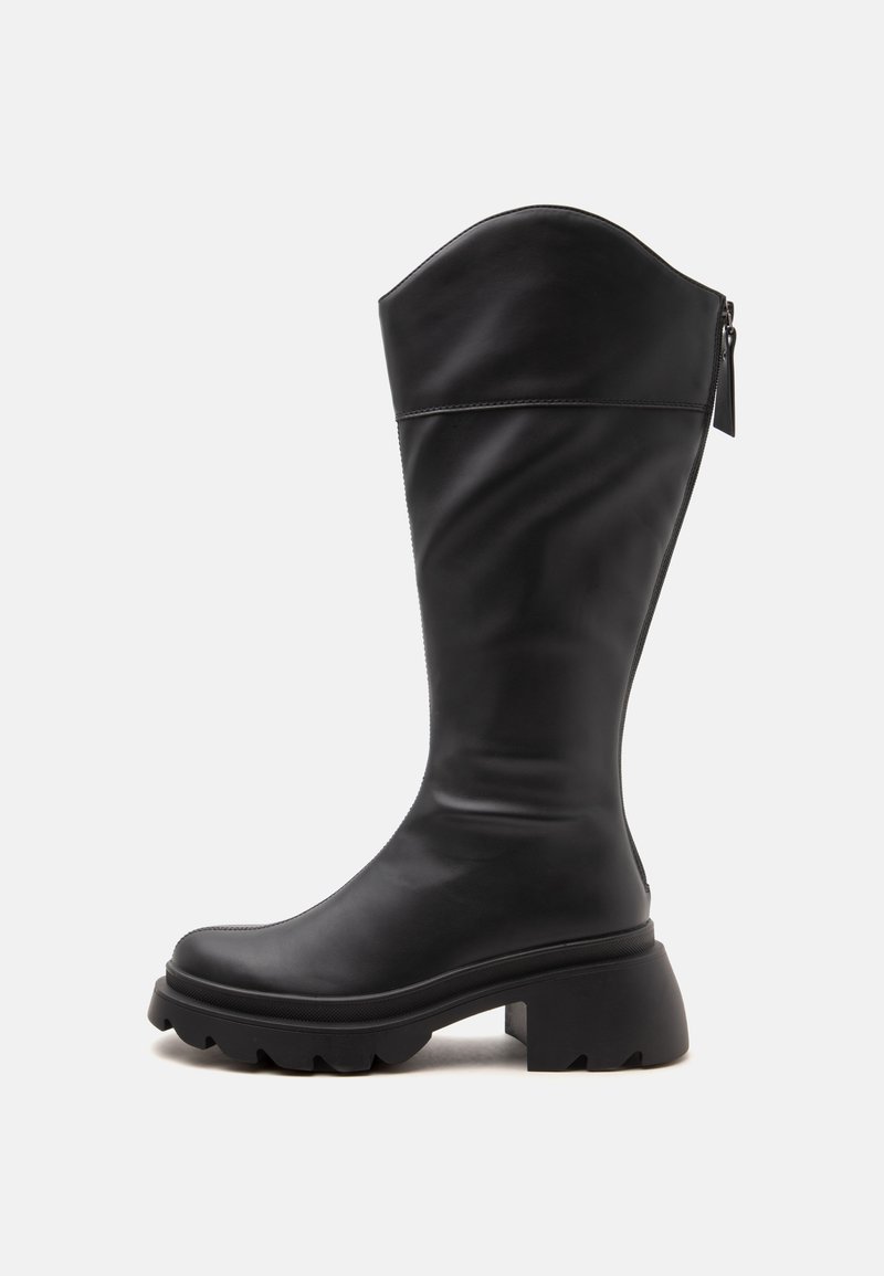 Botte en cuir noire mi-mollet avec semelle épaisse, talon carré et fermeture éclair à l’arrière.