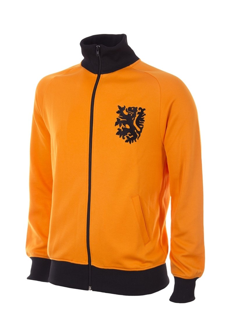 Giacca arancione con zip e colletto alto, dettagli neri e un emblema di leone sul petto. Presenta tasche laterali e polsini a coste.