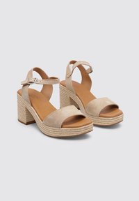 Sandalias de plataforma de ante beige con una amplia correa frontal, correa ajustable en el tobillo y un tacón tejido texturizado. Plantilla de cuero suave.