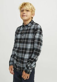 Camisa de franela a cuadros en negro y azul con cierre de botones, mangas largas y un ajuste relajado, que incluye cuello y puños con botones.