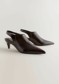 Tummanruskeat, kärkipäiset slingback-korkokengät, joissa on kiiltävä nahkapinta ja kohtuullinen korokepituus. Ominaisuuksina yksinkertainen muotoilu ja elastinen hihna.